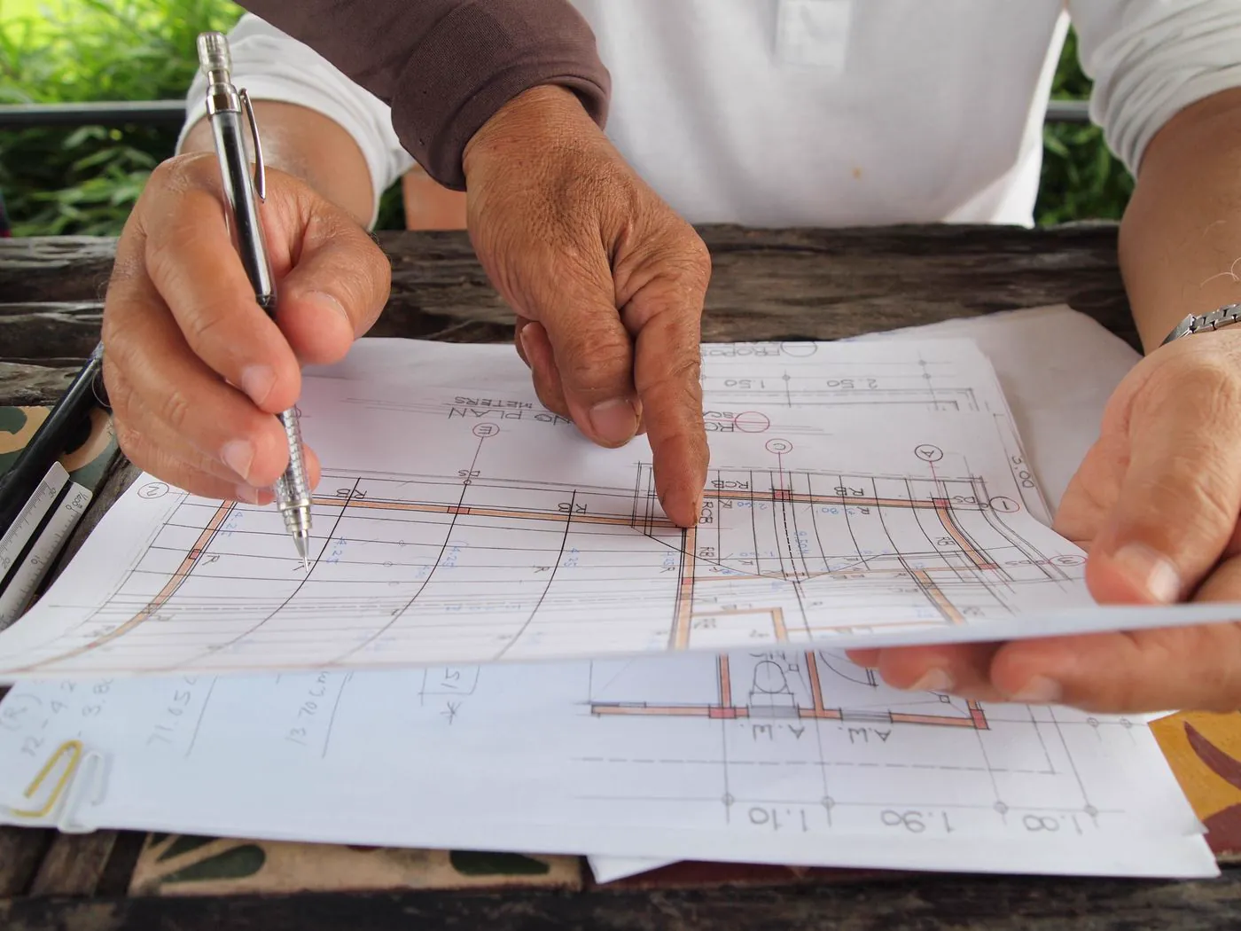 Mains examinant un plan architectural avec crayon